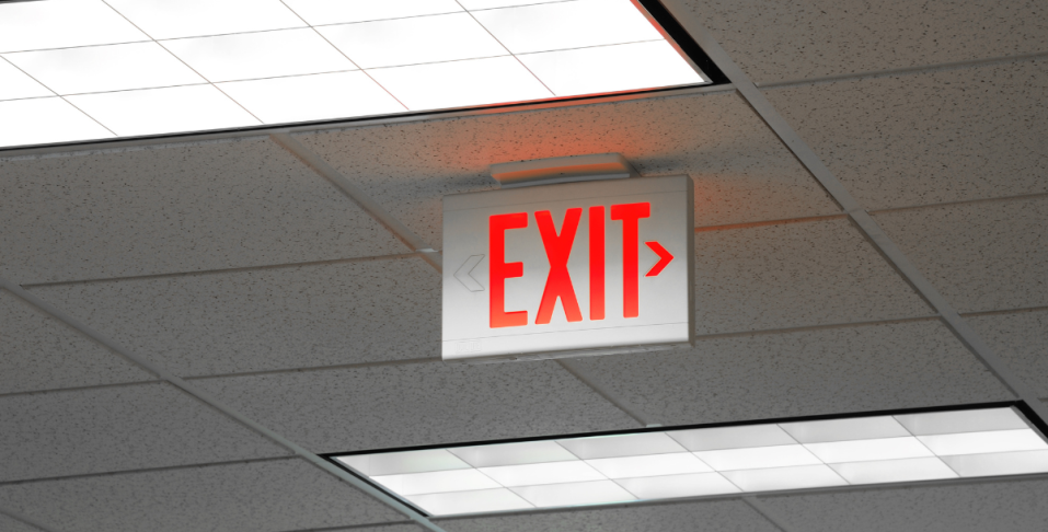 Red emergency exit sign hanging from ceiling