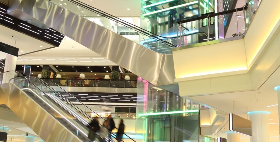 Mall with strip lights installed in elevator, escalator, and in recessed areas.